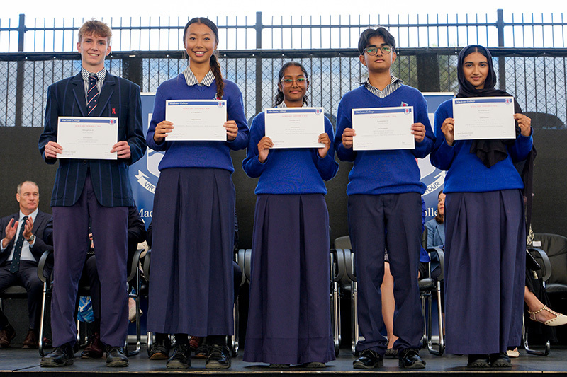 Macleans College students proudly displaying their certificates at Scholars Assembly