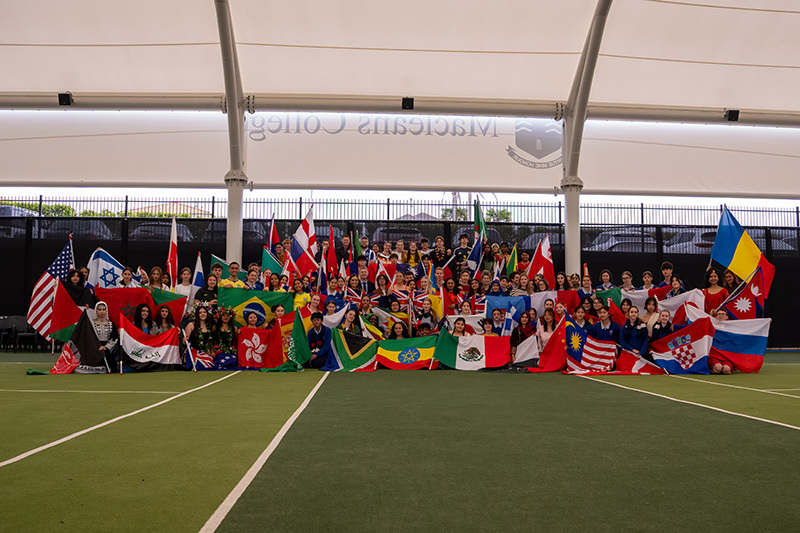 Macleans College students proudly displaying their countries' flags at the annual Flag Pageant