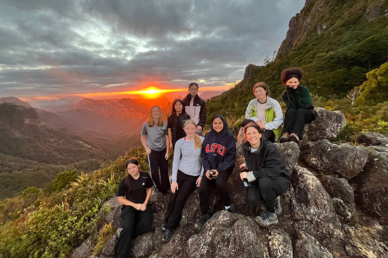 Macleans College students and their teacher hiking to a mountain top in the Coromandel Peninsula to watch the sunset